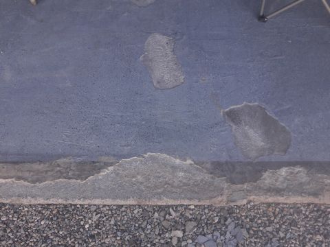 1957 Poison Spyder ZL 71 - A close-up view of a damaged concrete surface with gravel at the bottom, a watermark for Supermotors.net.