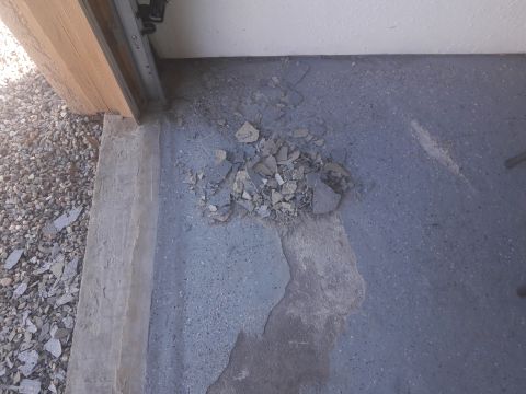 1957 Poison Spyder ZL 71 - Debris scattered on a garage floor, possibly from a damaged concrete surface.