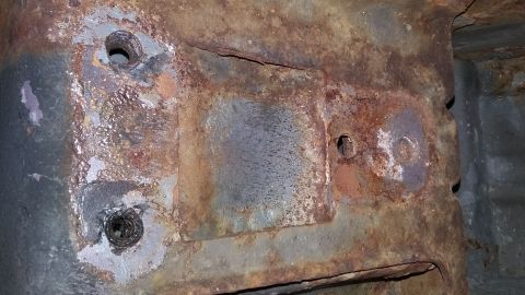 2000 Pontiac Grand Prix - Close-up of heavily rusted metal frame components, showing signs of significant corrosion and wear.