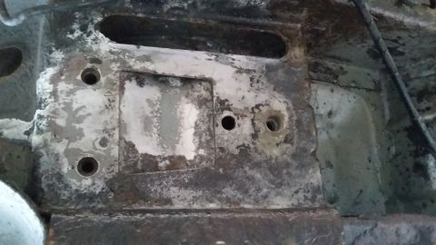 2000 Pontiac Grand Prix - Close-up view of a heavily rusted metal frame component with multiple bolt holes and mounting points.