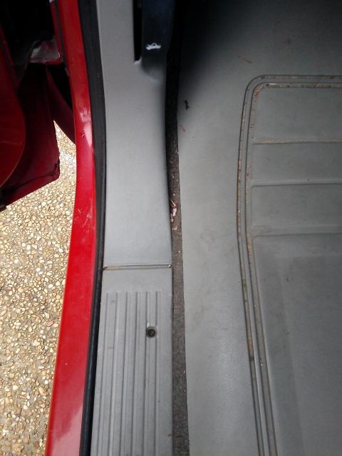 1998 Chevrolet C/K Pickup - Close-up view of the interior door sill and floor mat of a vehicle.