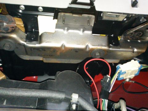 1998 Chevrolet C/K Pickup - This image shows a close-up view of electrical wiring and a metal bracket located under the dashboard of a vehicle.