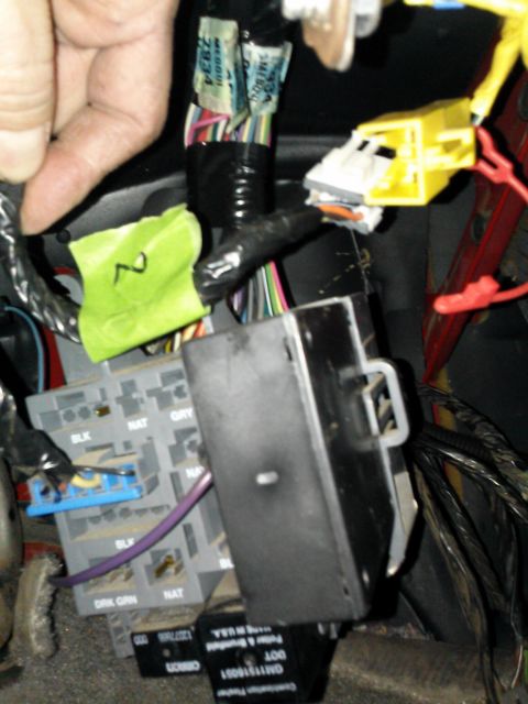 1998 Chevrolet C/K Pickup - Close-up view of the interior wiring harness and fuse box, a yellow airbag connector and various colored wires.