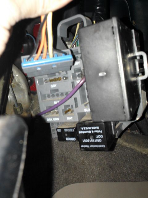 1998 Chevrolet C/K Pickup - Interior view of a vehicle's electrical system, showing a fuse box and wiring harness with various colored wires.
