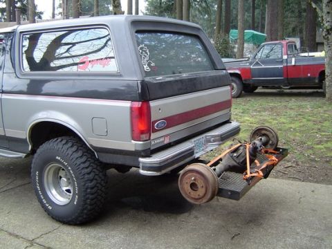 1988 Ford Bronco - A Ford Bronco is parked in a driveway with a differential loaded onto a carrier attached to its hitch.