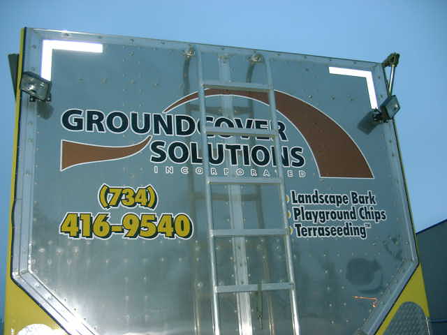 Rear of a truck with 'GROUND COVER SOLUTIONS INCORPORATED' logo, phone number (734) 416-9540, and services listed