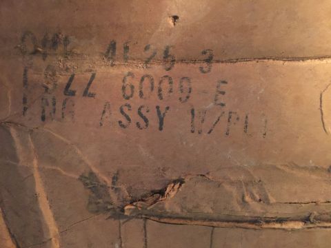 1973 Ford F-100 - Stenciled text on a brown, textured surface. The text appears to be a part number and description.