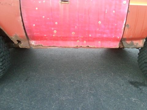 1984 Ford Bronco - Photo of a repaired and partially primered rocker panel on a red truck.