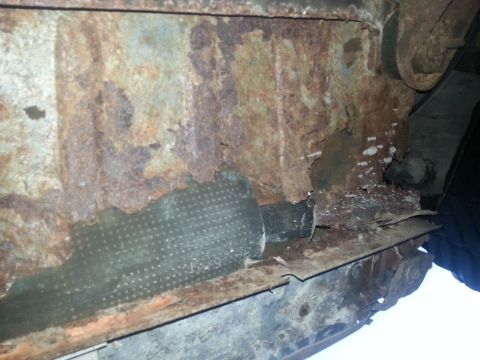 1984 Ford Bronco - Photo of severe rust and rot on a vehicle floor pan and rocker structure.
