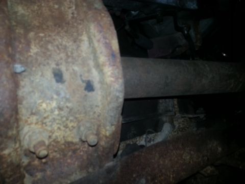 1984 Ford Bronco - Photo of a corroded rear axle, driveshaft and frame seen from under a vehicle.