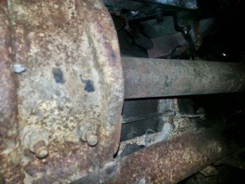 1984 Ford Bronco - Photo of a corroded rear axle, driveshaft and frame seen from under a vehicle.
