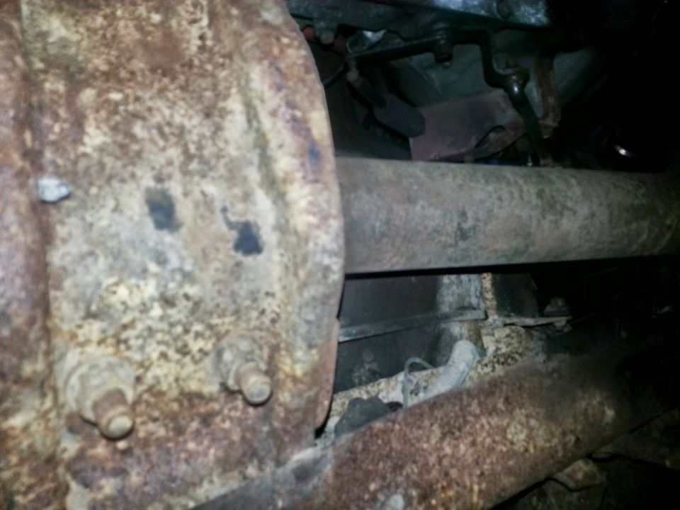 Rusty rear axle, driveshaft and frame under a vehicle