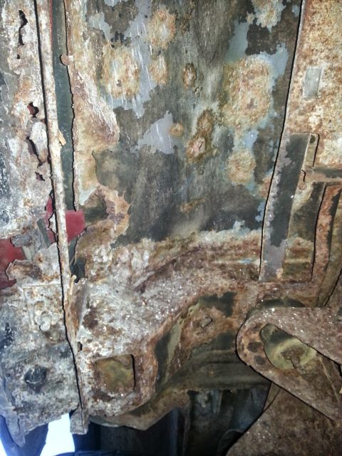 1984 Ford Bronco - Photo of extensive corrosion on a vehicle underbody floor and frame.