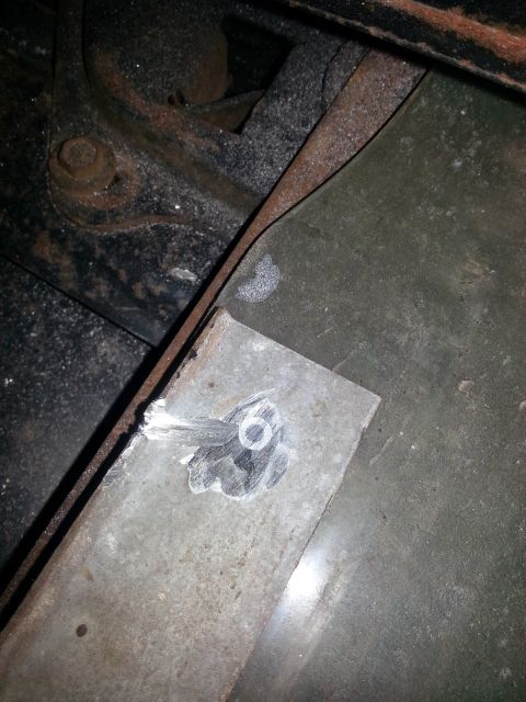 1984 Ford Bronco - Photo of a welded sheet-metal repair patch over an opening near a rusty frame bracket.