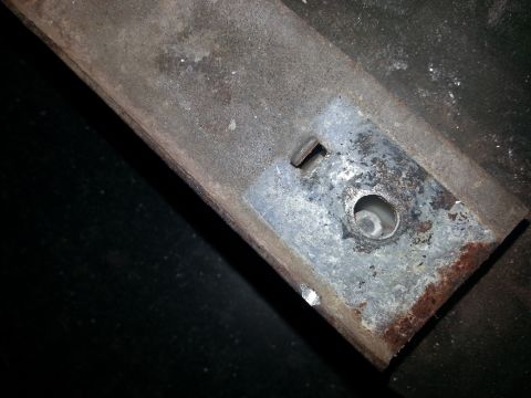 1984 Ford Bronco - Photo of a galvanized mounting plate with a round hole and slot welded onto a rusty body member.