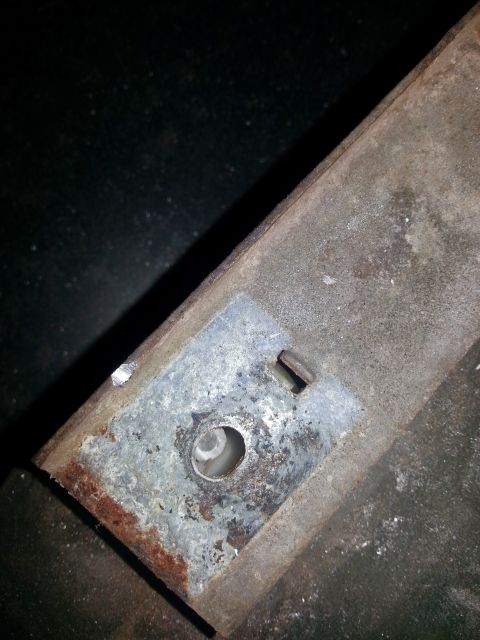 1984 Ford Bronco - Photo of a galvanized mounting plate with a hole and slot affixed to a corroded vehicle member.