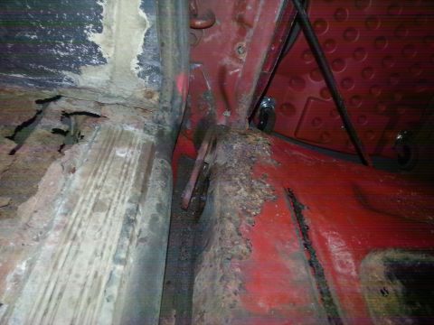 1984 Ford Bronco - Photograph of a rusted floor pan and rocker seam inside a vehicle during restoration, not a technical document.