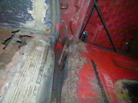 1984 Ford Bronco - Photograph of a rusted floor pan and rocker seam inside a vehicle during restoration, not a technical document.