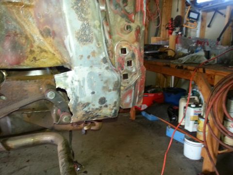 1984 Ford Bronco - Photograph of a corroded vehicle body panel in a workshop during restoration, not a technical document.