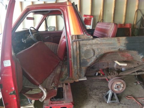 1984 Ford Bronco - Photograph of a partially dismantled pickup cab and bed during restoration, not a technical document.