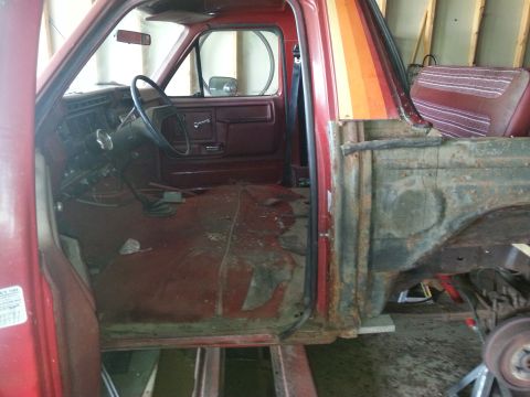 1984 Ford Bronco - Photograph of a red pickup cab interior and dash during restoration, not a technical document.