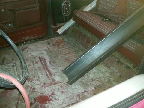 1984 Ford Bronco - Photograph of a stripped truck cab floor during restoration, not a technical document.