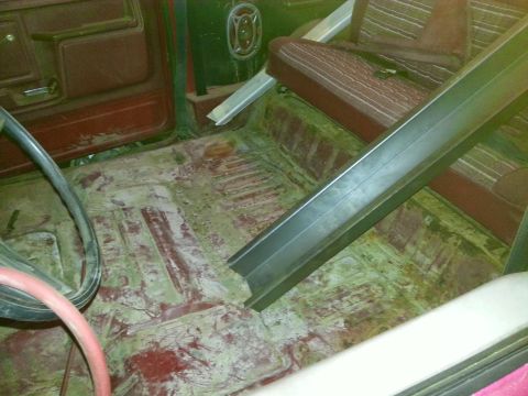 1984 Ford Bronco - Photograph of a stripped truck cab floor during restoration, not a technical document.