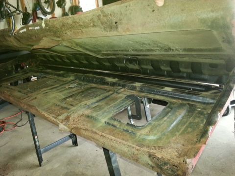1984 Ford Bronco - Photo of the underside of a rusty truck bed panel clamped on a shop workbench.