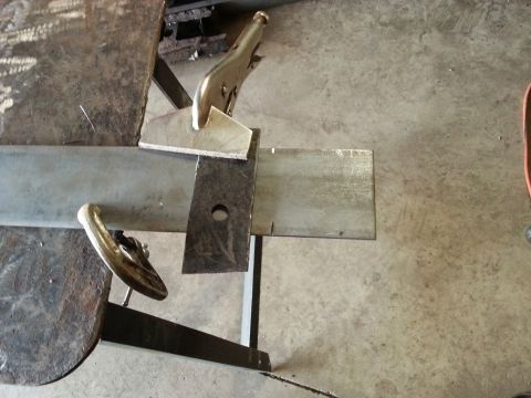 1984 Ford Bronco - Photo of a metal plate held by locking pliers during fabrication on a shop table.