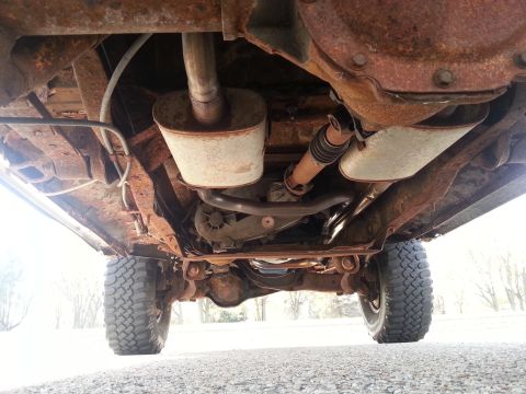 1984 Ford Bronco - Photo of a vehicle undercarriage showing the rear axle, driveshaft and shock absorbers, not a document.