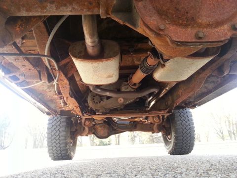 1984 Ford Bronco - Photo of a vehicle undercarriage showing the rear axle, driveshaft and shock absorbers, not a document.