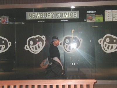 1997 Ford Taurus - A person stands in front of the Newbury Comics store, which has large cartoon faces on its glass doors.