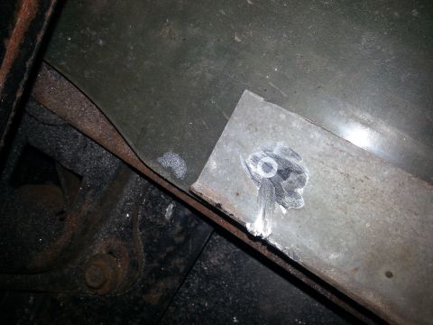 1984 Ford Bronco - Photograph of a newly welded metal body-mount plate on a rusty vehicle frame rail, not a document.