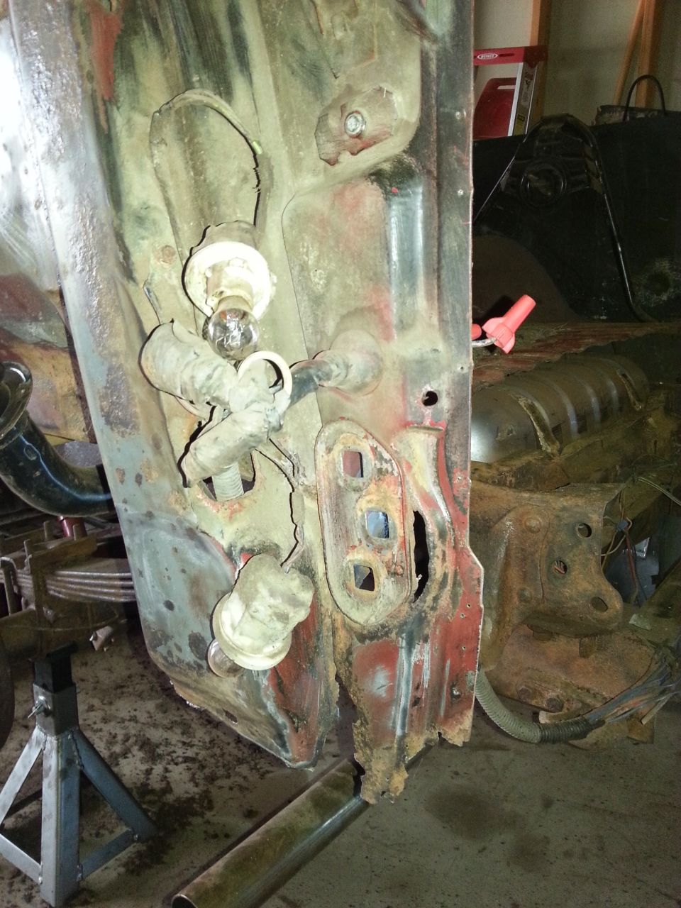 Rusty vehicle body panel propped on jack stands