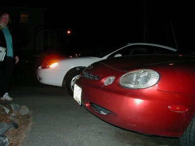 1997 Ford Taurus - Two cars are parked outside at night, with a person standing on the left side of the frame.