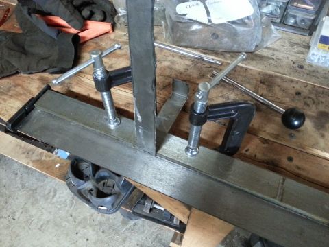 1984 Ford Bronco - Photograph of clamped steel parts during metal fabrication, not a document.