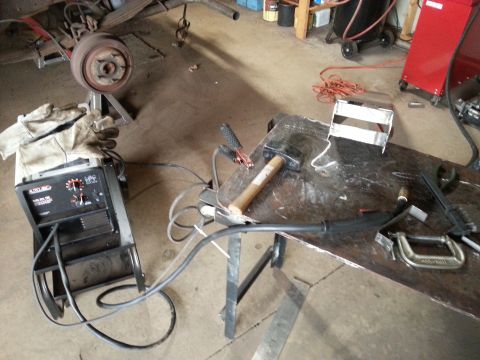 1984 Ford Bronco - Photograph of a welding machine and tools on a workbench in a garage, not a document.