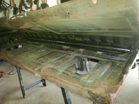 1984 Ford Bronco - Photograph of a removed pickup truck bed floor and side panel resting on stands during a restoration.