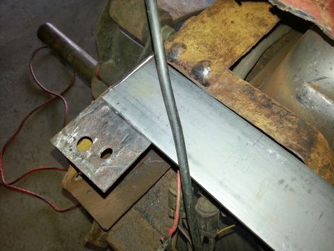 1984 Ford Bronco - Photograph of a bare steel bar and drilled bracket secured in a shop bench vise.