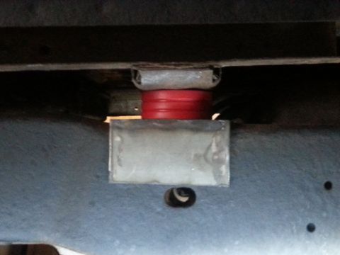 1984 Ford Bronco - Close-up of a suspension lift block and red polyurethane spacer.