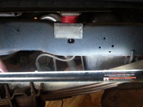 1984 Ford Bronco - Close-up view of the undercarriage of a vehicle, showing suspension components and a work light.