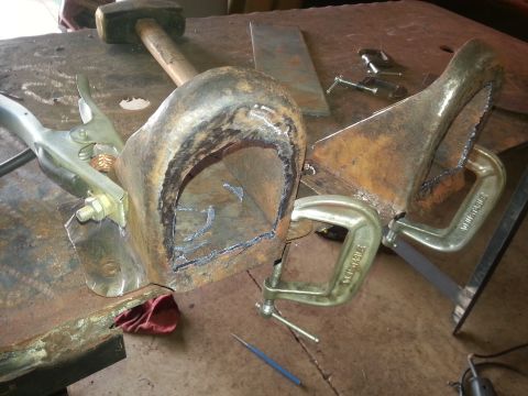 1984 Ford Bronco - Metal fabrication in progress on a workbench, clamped parts and welding tools.