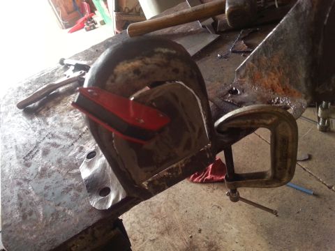 1984 Ford Bronco - A metal component is secured with clamps and a magnet on a workbench, possibly for repair or fabrication.
