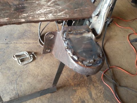 1984 Ford Bronco - Metal bracket being worked on with welding equipment and clamps.