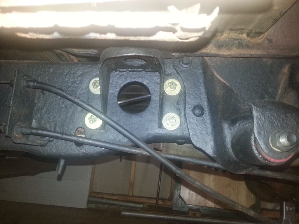 Close-up of a vehicle's rear axle suspension bracket and mounting bolts