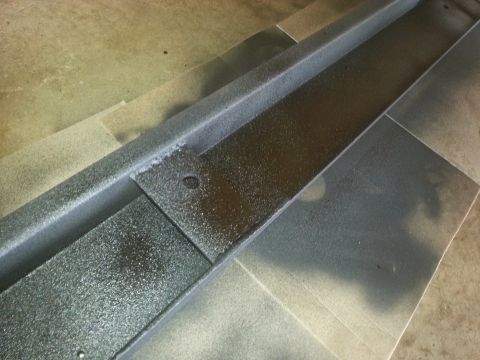 1984 Ford Bronco - This metal component has been painted with a textured finish, showing a circular hole and a seam.
