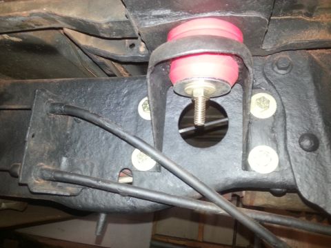 1984 Ford Bronco - Close-up of a vehicle's undercarriage shows a red bushing attached to the frame.
