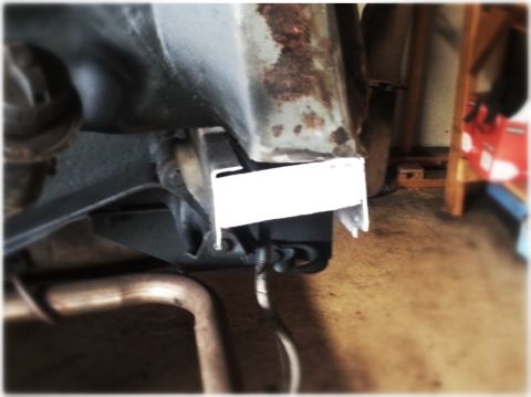 1984 Ford Bronco - This image shows a close-up of a vehicle's undercarriage, focusing on the frame and exhaust system.