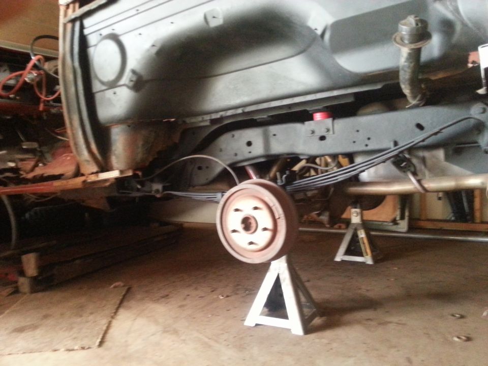 Undercarriage with rear drum brake on jack stand, leaf springs visible