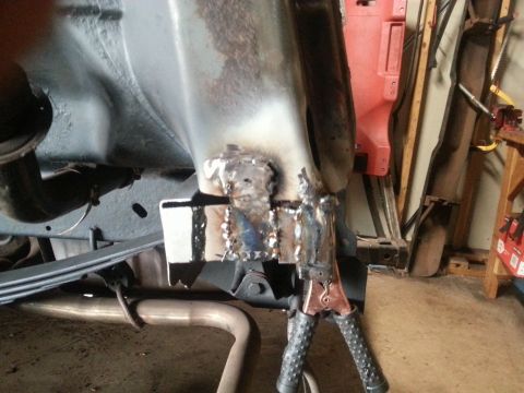 1984 Ford Bronco - Welding repair in progress on a vehicle frame, with jumper cables attached to the metal.
